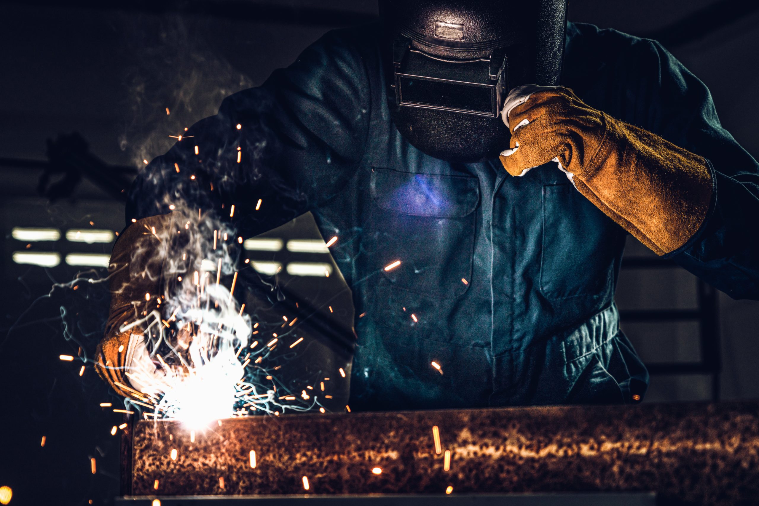Metal welder working with arc welding machine.